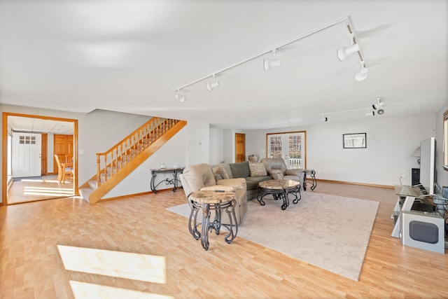 living room with light wood-type flooring and track lighting