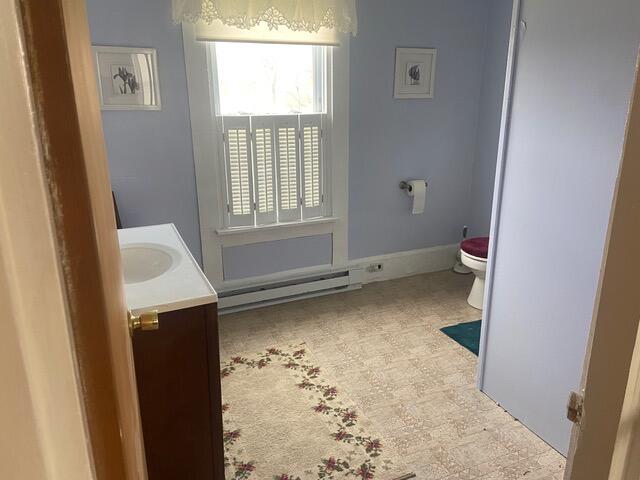 bathroom with vanity, a baseboard radiator, and toilet