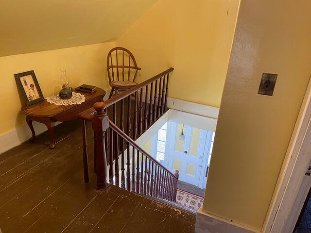 stairway with hardwood / wood-style floors and lofted ceiling