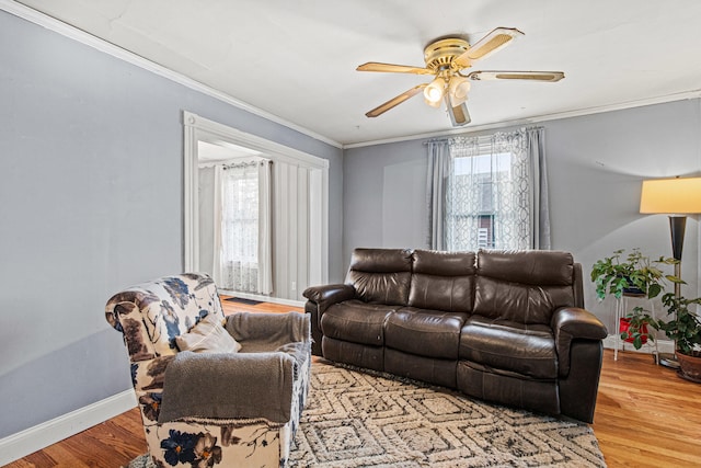 living room with wood-type flooring, a healthy amount of sunlight, and ornamental molding