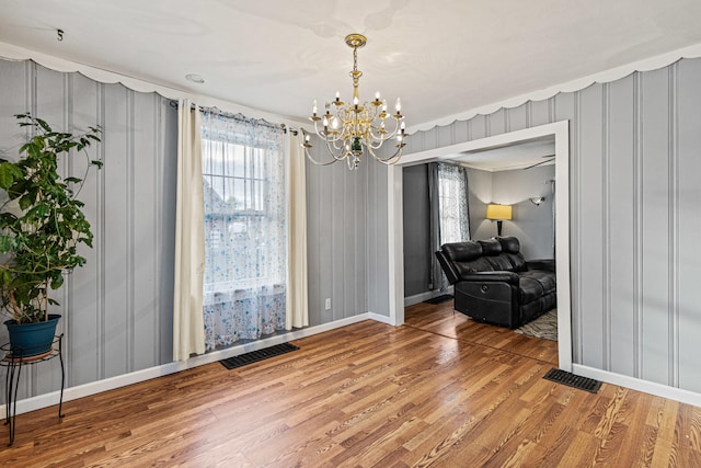 interior space featuring ornamental molding, hardwood / wood-style floors, and a chandelier