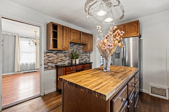 kitchen featuring butcher block countertops, dark hardwood / wood-style floors, tasteful backsplash, and an inviting chandelier