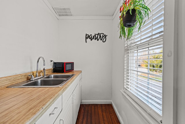 kitchen featuring white cabinets, dark hardwood / wood-style floors, sink, and crown molding