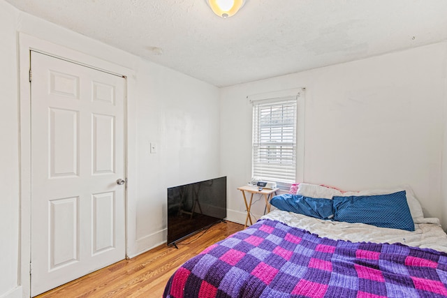 bedroom with wood-type flooring and a textured ceiling