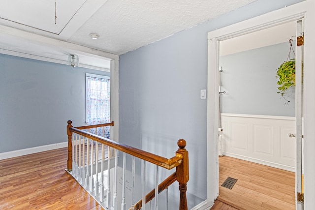 corridor with hardwood / wood-style floors and a textured ceiling