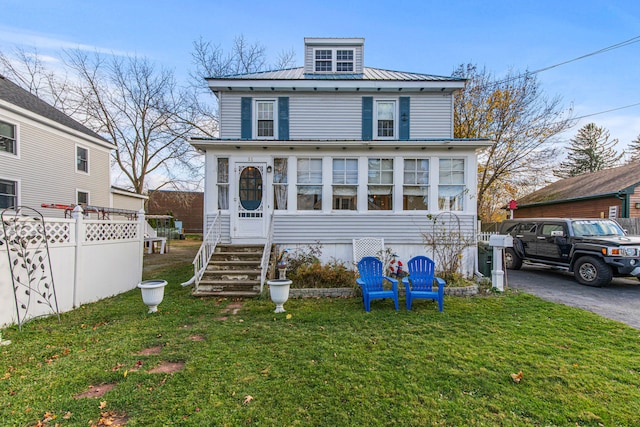 view of front of house with a sunroom and a front lawn