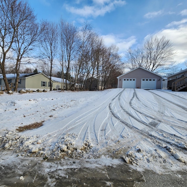 yard layered in snow with an outbuilding and a garage