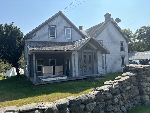 back of property with french doors and a lawn