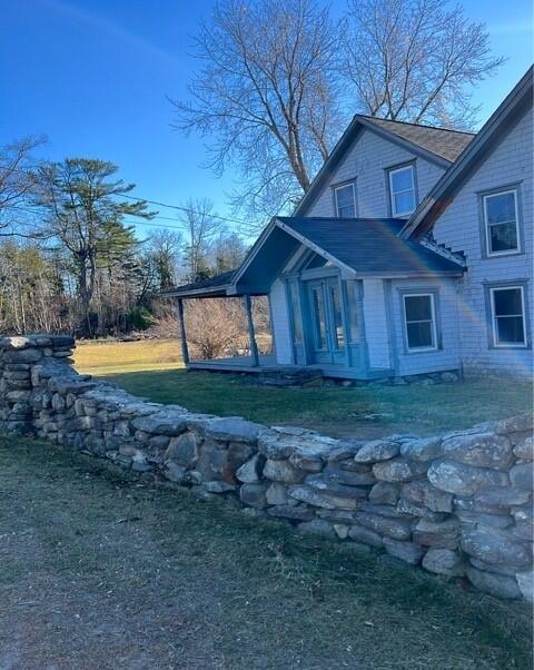 view of property exterior featuring a lawn and a patio area