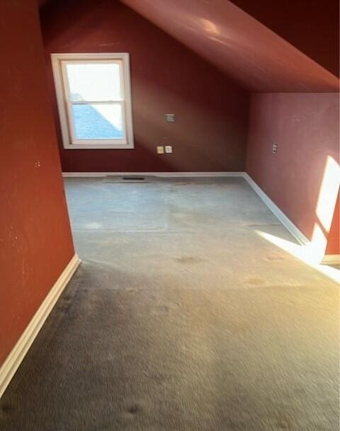 bonus room with carpet floors and vaulted ceiling