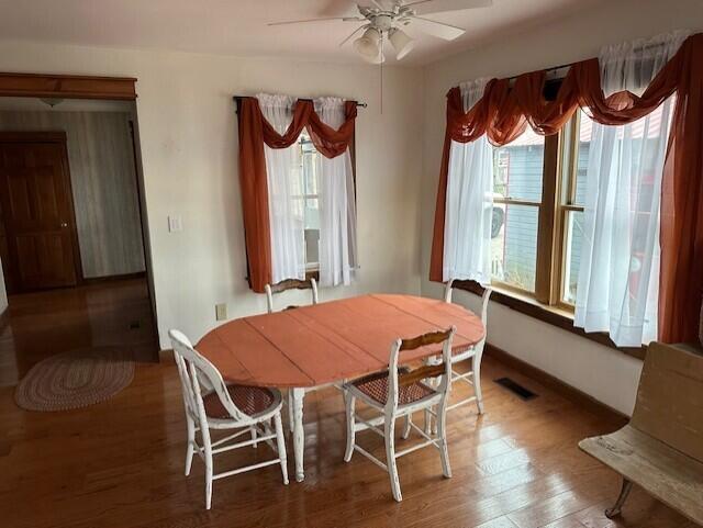 dining space with hardwood / wood-style flooring and ceiling fan