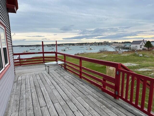 deck with a water view and a yard