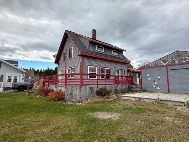 view of front of property with a wooden deck and a front yard