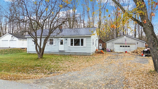 view of front of property featuring a garage, a front yard, and an outdoor structure