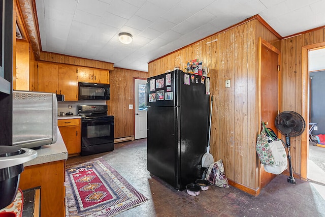 kitchen with black appliances, wood walls, and a baseboard heating unit