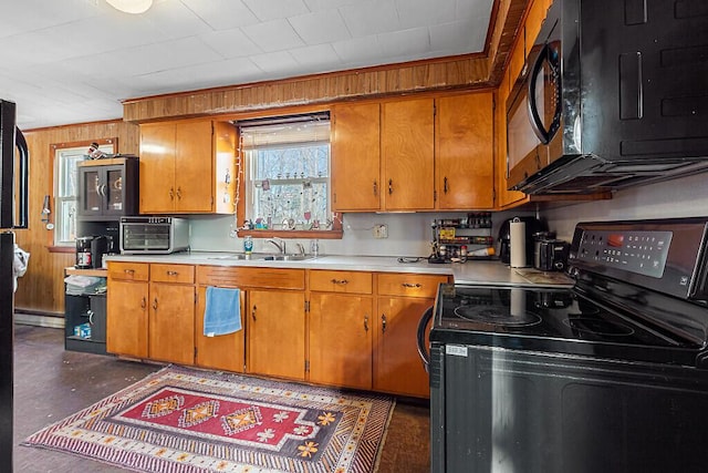 18 Sebasticook Dr, Clinton, ME 04927 - kitchen featuring black appliances, light countertops, brown cabinets, wood walls, and a sink