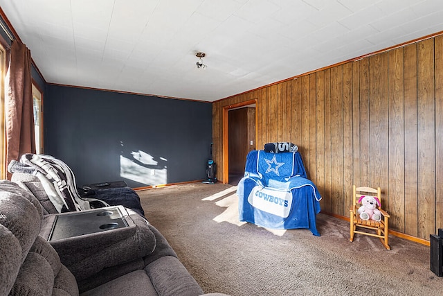 sitting room featuring carpet flooring, wood walls, and ornamental molding