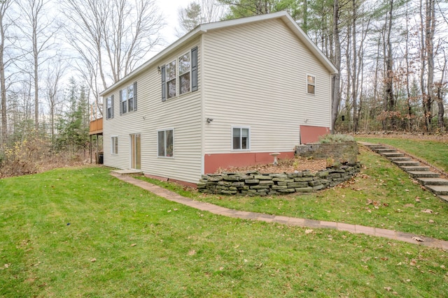 view of side of property with a wooden deck and a yard