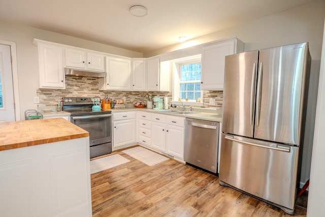 kitchen featuring white cabinetry, sink, wooden counters, light hardwood / wood-style floors, and appliances with stainless steel finishes