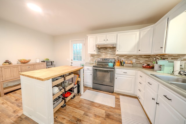 kitchen with wooden counters, light wood-type flooring, stainless steel appliances, and white cabinetry