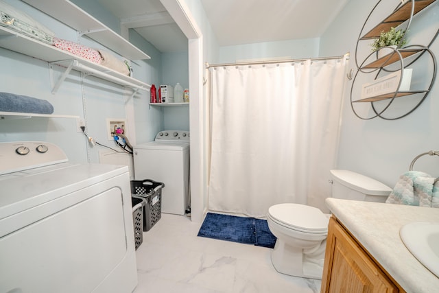 bathroom with vanity, washing machine and dryer, and toilet