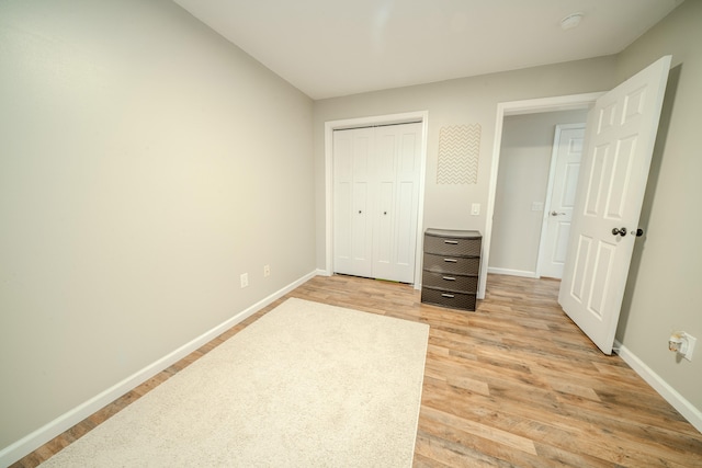 unfurnished bedroom featuring light hardwood / wood-style flooring and a closet