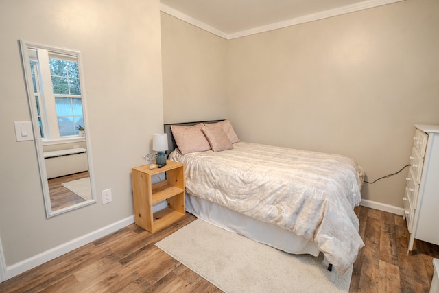 bedroom featuring wood-type flooring and crown molding