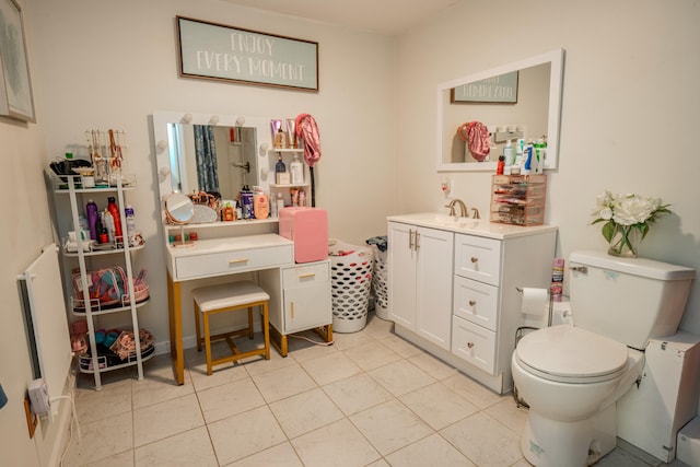 bathroom with tile patterned flooring, vanity, and toilet