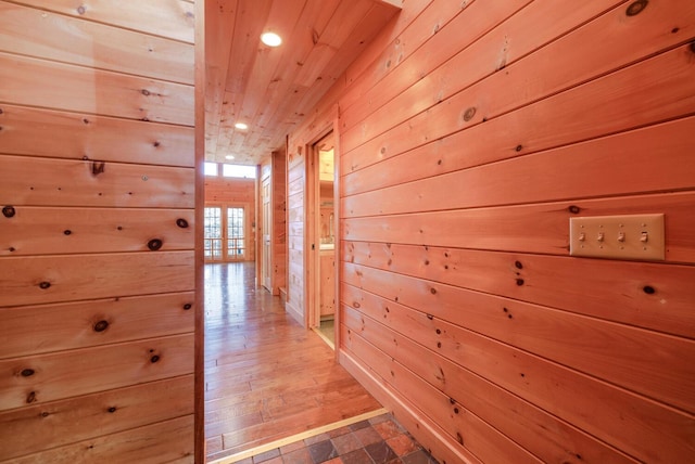 corridor featuring hardwood / wood-style floors and wooden walls