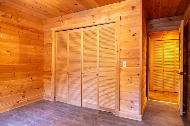 unfurnished bedroom featuring dark hardwood / wood-style floors, wooden walls, and wood ceiling