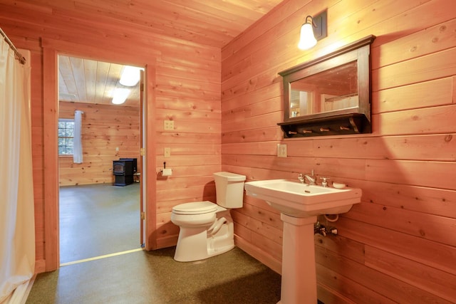 bathroom featuring sink, toilet, wooden walls, and wood ceiling