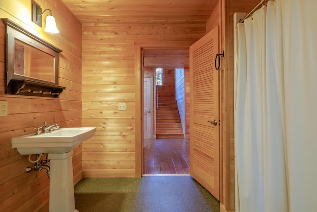 bathroom featuring wood-type flooring, curtained shower, wooden ceiling, and wood walls