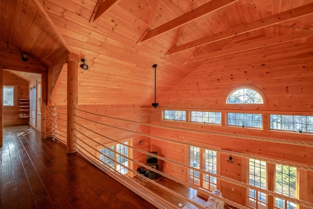 hallway featuring beamed ceiling, dark hardwood / wood-style floors, wooden ceiling, and wooden walls