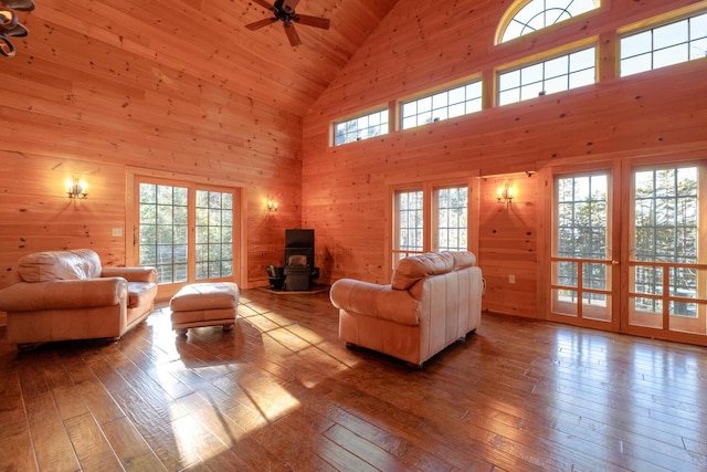 1700 Tremont Rd, Tremont, ME 04674 - living area featuring high vaulted ceiling, a wood stove, hardwood / wood-style flooring, ceiling fan, and wood walls