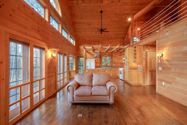 living room featuring ceiling fan, wood walls, high vaulted ceiling, and hardwood / wood-style flooring