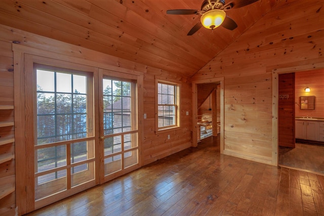 interior space with lofted ceiling, wooden walls, ceiling fan, light hardwood / wood-style floors, and wood ceiling