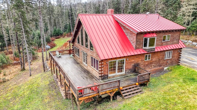 658 Mingo Loop Rd, Rangeley, ME 04970 - back of house with log siding, a chimney, a deck, and a view of trees