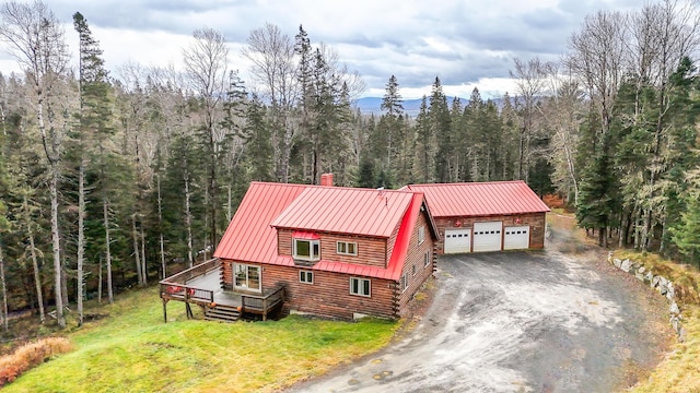 658 Mingo Loop Rd, Rangeley, ME 04970 - view of front facade featuring log exterior, a forest view, a wooden deck, a front lawn, and metal roof