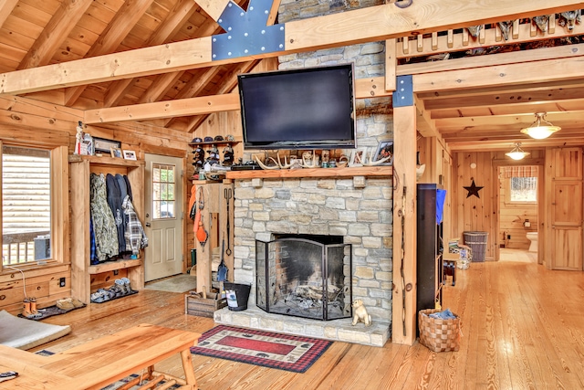 living room with wooden walls, lofted ceiling with beams, wood-type flooring, and wood ceiling