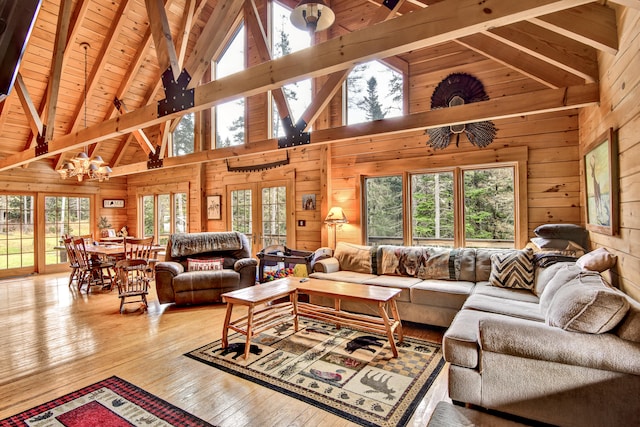 living room with beam ceiling, hardwood / wood-style flooring, high vaulted ceiling, and wooden walls