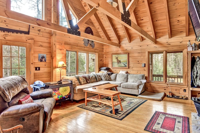 658 Mingo Loop Rd, Rangeley, ME 04970 - living area with plenty of natural light, hardwood / wood-style floors, wood ceiling with exposed beams, wood walls, and high vaulted ceiling