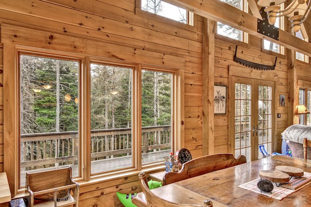 dining space featuring a wealth of natural light, french doors, and wood walls