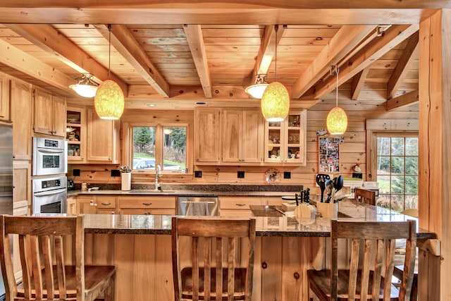 658 Mingo Loop Rd, Rangeley, ME 04970 - kitchen with wood ceiling with exposed beams, a sink, appliances with stainless steel finishes, healthy amount of natural light, and a kitchen bar
