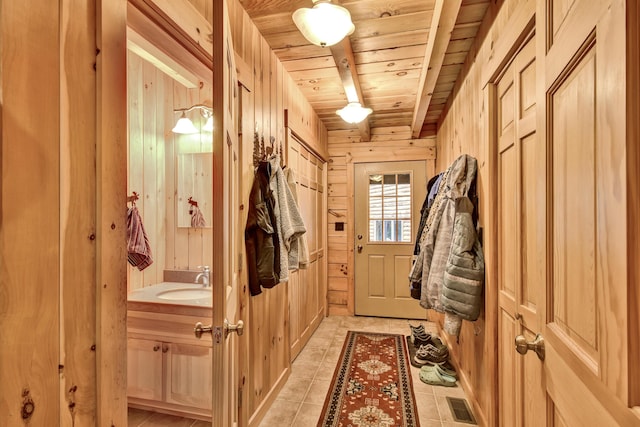 658 Mingo Loop Rd, Rangeley, ME 04970 - entryway featuring wooden ceiling, wooden walls, a sink, and light tile patterned flooring