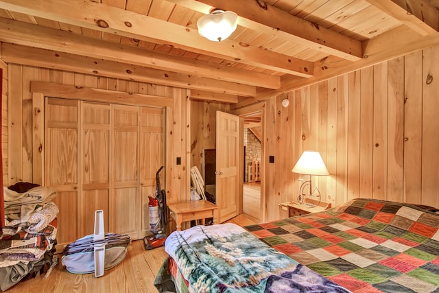 bedroom with wood walls, beam ceiling, wood-type flooring, and wooden ceiling