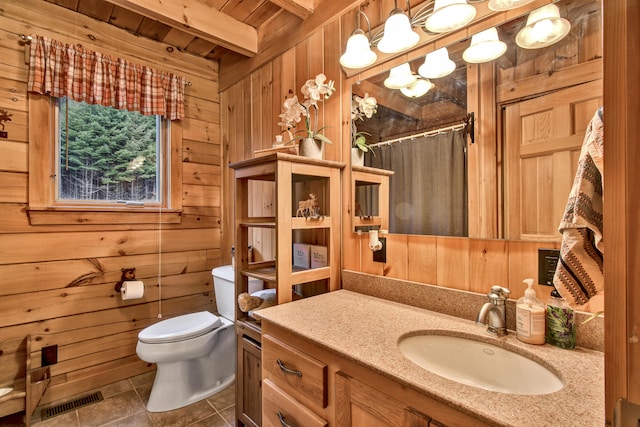 bathroom with vanity, wood walls, tile patterned flooring, toilet, and beamed ceiling