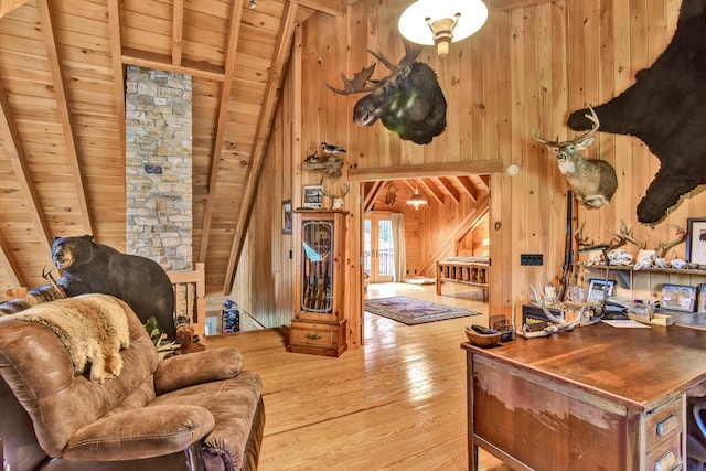 living room with wooden walls, wood-type flooring, beam ceiling, high vaulted ceiling, and wooden ceiling