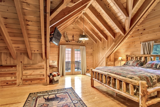 bedroom featuring vaulted ceiling with beams, wood walls, french doors, and light wood-type flooring