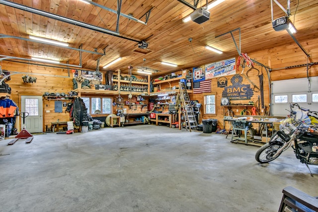 garage with a workshop area, a garage door opener, and wooden walls