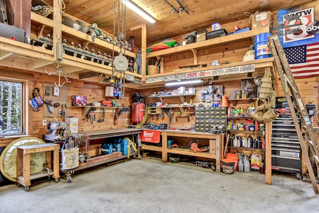 garage with a workshop area, wood walls, and wood ceiling